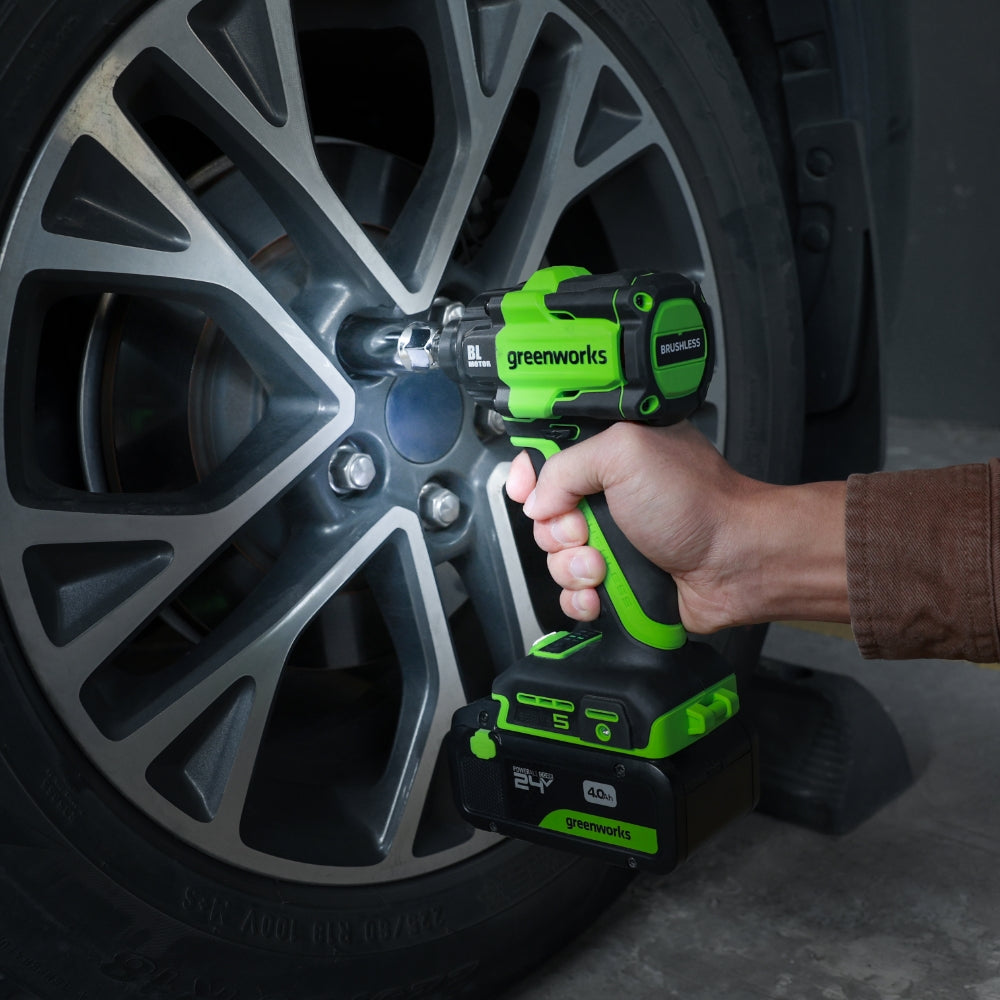 Person using a Greenworks impact wrench on a car tire