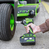 Person using a Greenworks cordless drill on a lawn mower.