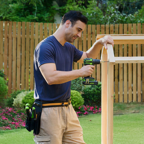 Man using a drill on a wooden project outdoors