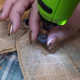 Person using a green tool on burlap fabric